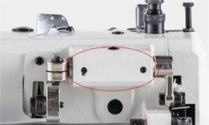 Dixie Tailoring Supply Close-up of the Jack H2 Industrial Walking Foot Sewing Machine, with a red oval highlighting a rectangular metal section and two screws. Tailoring Supplies