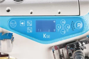 Dixie Tailoring Supply Close-up of the blue digital control panel labeled "K5E" on the Jack K5 UT01GB Automatic Cylinder Arm Coverstitch Industrial Sewing Machine, featuring various buttons and icons. Tailoring Supplies