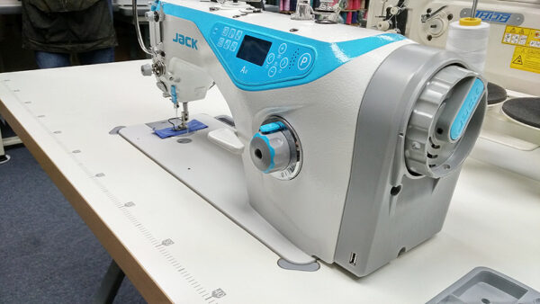 Dixie Tailoring Supply Close-up of the JACK A4 Fully Automatic Industrial Sewing Machine with digital controls, perfectly positioned on a white table, highlighting the craftsmanship in this vibrant tailoring store workshop. Tailoring Supplies