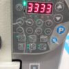 Dixie Tailoring Supply A close-up of the JACK A2S Automatic Industrial Single Needle Sewing Machine's digital control panel shows the number 3333 in red, accompanied by various buttons and icons with text in an Asian script, ideal for tailoring stores seeking precision. Tailoring Supplies