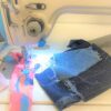 Dixie Tailoring Supply The JACK F4 Sewing Machine gently hums as it precisely stitches multi-colored fabric and denim. Under bright light, this essential tailoring tool seamlessly brings creations to life, embodying the heart of any tailor’s shop. Tailoring Supplies
