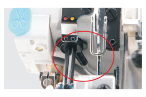 Dixie Tailoring Supply Close-up of the JACK C4 Fully Automatic Overlock Sewing Machine mechanism, showing metal rods and parts, with a red circle highlighting a specific component for emphasis. Tailoring Supplies