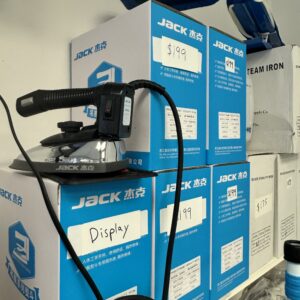 Dixie Tailoring Supply Several boxes labeled "JACK" are stacked on shelves with price tags, and a Gravity Steam Iron is displayed on top. Tailoring Supplies