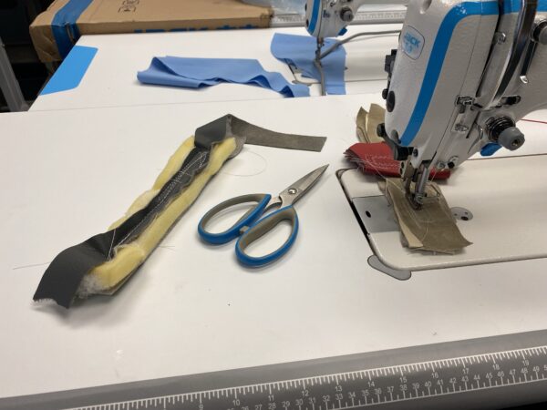 Dixie Tailoring Supply On a white surface sits the JACK H2 Industrial Walking Foot Sewing Machine surrounded by fabric pieces, blue-handled scissors, and a ruler. Ideal for tailors, these items showcase the precision and style of expert tailoring products. Tailoring Supplies