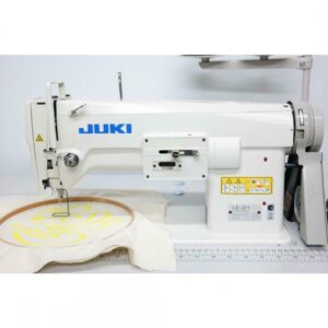 Dixie Tailoring Supply A close-up of the JUKI LZ 271 Industrial Embroidery Sewing Machine (white color) is shown with a fabric hoop. The yellow stitching on cream fabric emphasizes its precision, making it ideal for tailoring stores seeking excellent craftsmanship. Tailoring Supplies